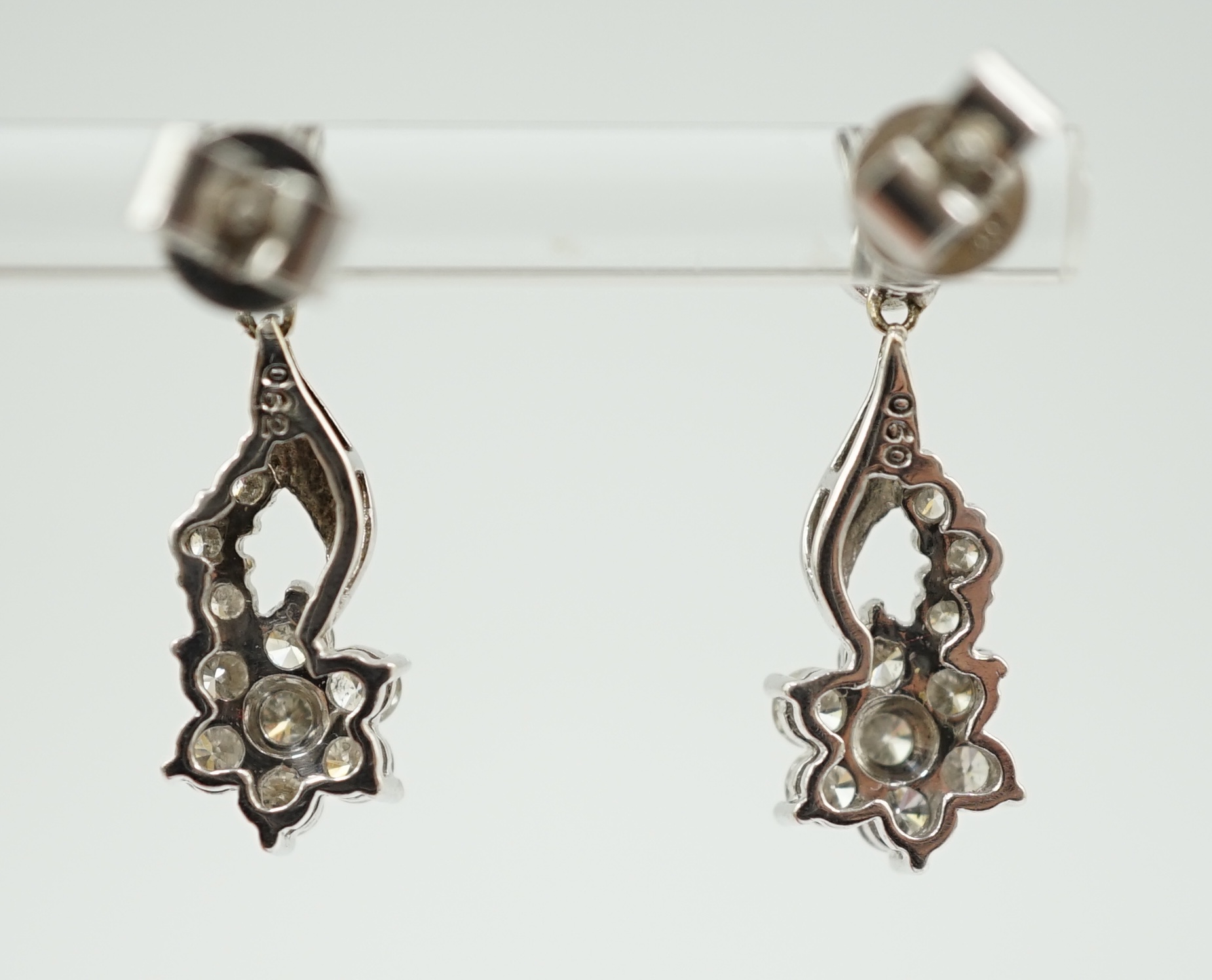 A modern pair of 18k white gold and diamond cluster ear studs, each modelled as a flower with stem